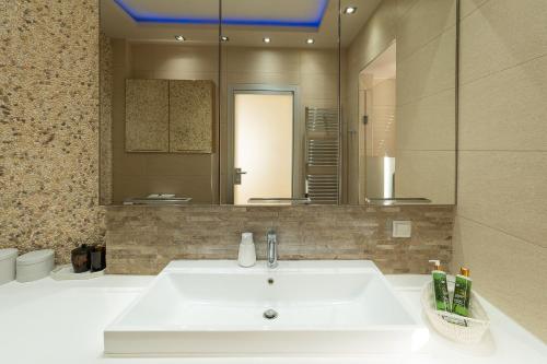 a bathroom with a sink and a large mirror at Royal Luxury Villa by AKTIS VILLAS in Kriopigi