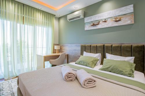 a bedroom with a large bed with towels on it at Royal Luxury Villa by AKTIS VILLAS in Kriopigi