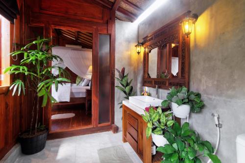 a bathroom with a sink and a mirror and some plants at The Cottage By Selasih in Seminyak