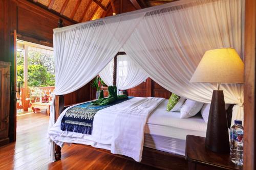 a bedroom with a bed with a canopy at The Cottage By Selasih in Seminyak