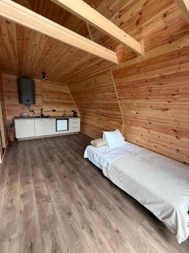 a bedroom with a bed in a wooden cabin at Vis de Munte Chalet in Buhalniţa
