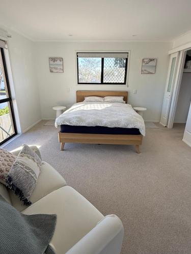 a bedroom with a bed and a couch at Beachside Studio Apartment in Bargara
