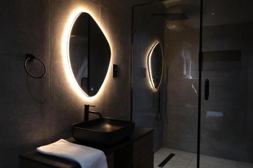 a bathroom with a sink and a mirror and a shower at Black Muse Residence in Benin City