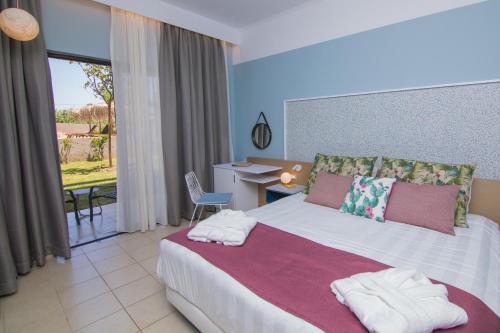 a bedroom with a bed with towels on it at Lindos Breeze Beach Hotel in Kiotari