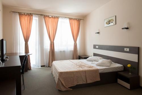 1 dormitorio con cama y ventana grande en Casa Vanatoreasca, en Mogoşoaia