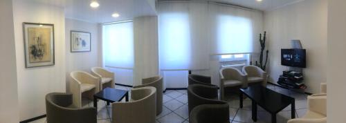 a waiting room with chairs and a table and a television at Hotel Al Capo in Varigotti