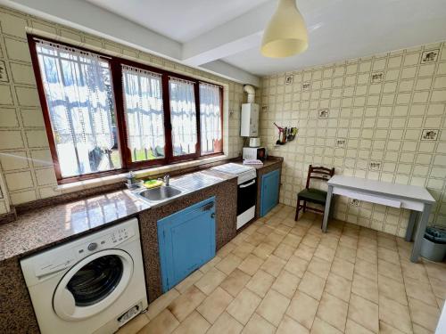 a kitchen with a washing machine and a sink at La Xastra in Celorio