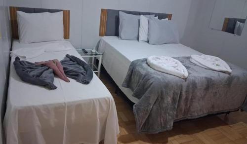 two beds sitting next to each other in a room at Hotel Linassi in Cruz Alta