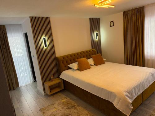 a bedroom with a large bed with brown pillows at Casa Runc in Şarul Dornei
