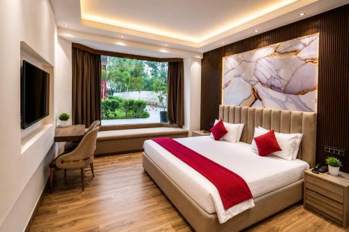 a bedroom with a large bed and a window at The Aura Hotel & Resort in Noida