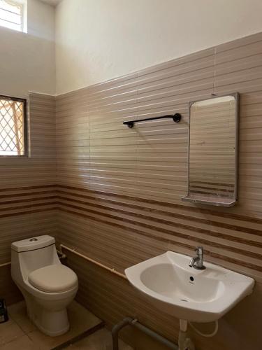 a bathroom with a toilet and a sink at Mandira Homes in Mysore