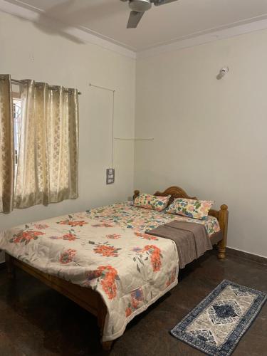 a bedroom with a bed and a window at Mandira Homes in Mysore