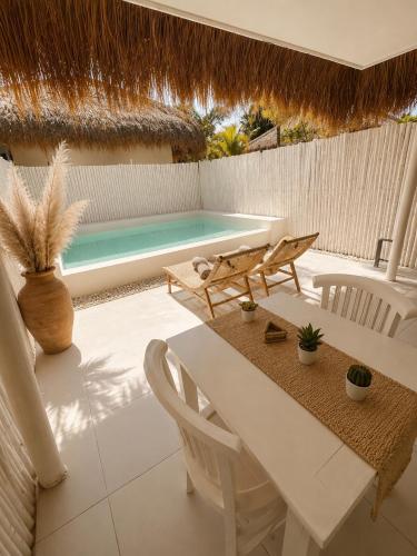 a patio with a table and chairs and a swimming pool at Villa Samalas Boutique Resort & Private Pool Villas in Gili Meno