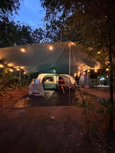 a tent with a car and a person sitting in it at Flor de Lótus Camping in Japaratinga