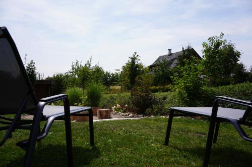 two chairs sitting in the grass in a yard at Pod křídly Krkonoš in Černý Dŭl