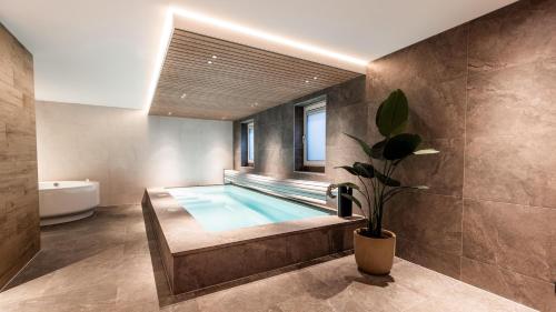 a bathroom with a swimming pool with a tub at Resort Valley in Wekerom
