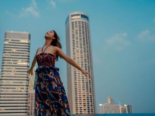 a woman in a dress standing in front of a city at Swissotel The Stamford Singapore in Singapore