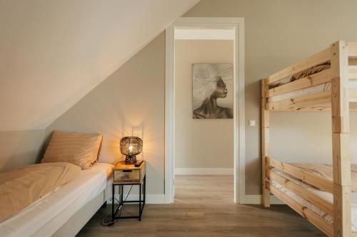 a bedroom with a bunk bed and a lamp on a table at Resort Valley in Wekerom