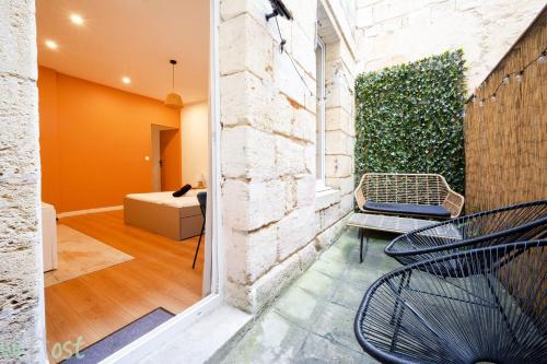 a patio with two chairs and a couch in a room at Charmant cocon avec jacuzzi - Bordeaux Centre in Bordeaux