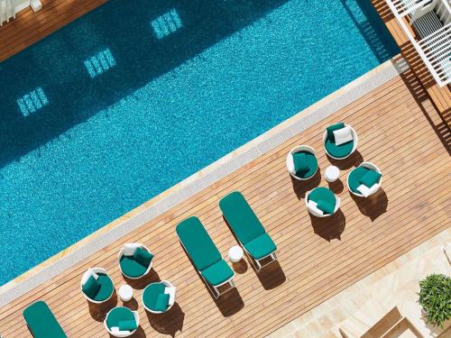 an overhead view of a swimming pool with chaise lounge chairs and a swimming pool at Swissotel Sydney in Sydney