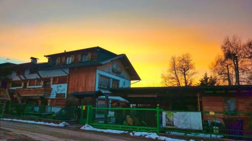 a building with a sunset in the background at Albergo Garni Villa Lory in Baselga di Pinè