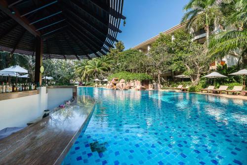 a swimming pool with blue water in a resort at Ravindra Beach Resort & Spa - SHA Extra Plus in Na Jomtien