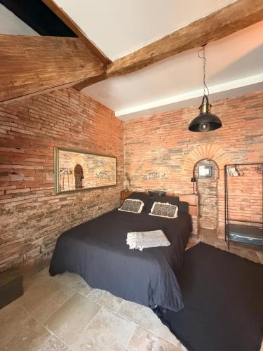 a bedroom with a bed in a brick wall at Independent charming studio in Gibel