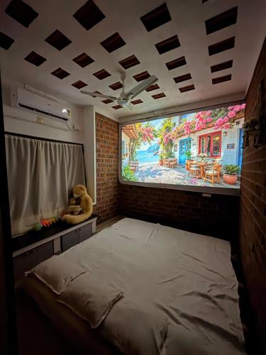 a room with a bed with a large painting on the wall at Escape Inn in Trivandrum