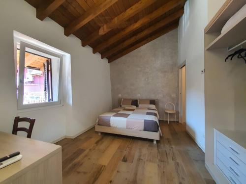 a bedroom with a bed and a wooden floor at La Cà de' mi Vecc in Fino Mornasco