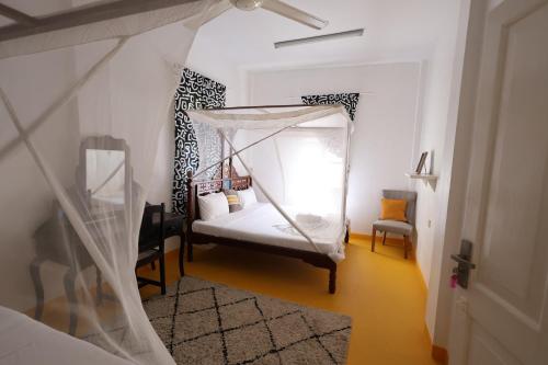 a bedroom with a bed with a canopy at NOMAD Hostel Stone Town in Zanzibar City