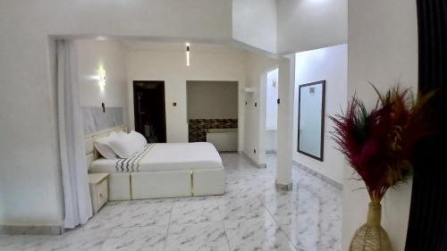 a white bedroom with a bed and a bathroom at Villa de 3 chambres avec jaccuzzi in Porto-Novo