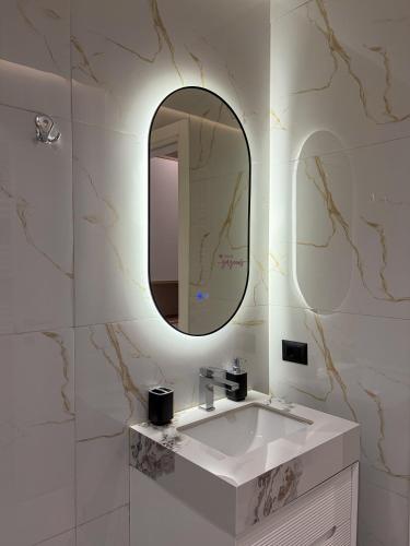 a bathroom with a white sink and a mirror at Casa Tirana in Tirana