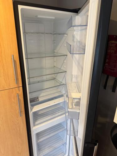 an empty refrigerator with its door open at Spacious 5BR House Free Parking hatfield in Hatfield