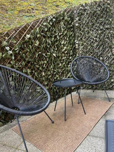 two black chairs sitting next to a fence at Studio Belaj in Celje