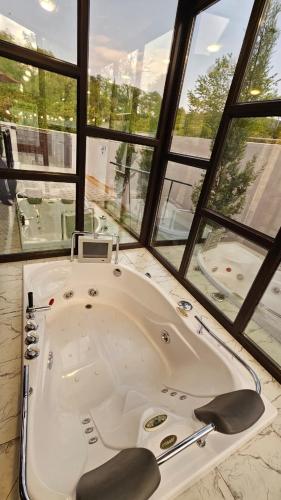 a large bath tub in a room with windows at SILAND A Frame House in Gabala
