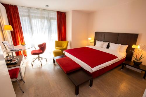 a hotel room with a bed and a desk and a desk at Design Hotel Zollamt in Kaiserslautern