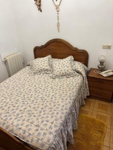 a bedroom with a bed and a table with a phone at Casa villada in Villada