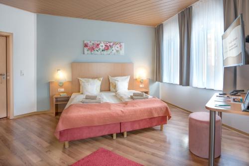 a bedroom with a large bed with a pink blanket at Schlossberghotel Oberhof in Oberhof