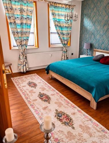 ein Schlafzimmer mit einem grünen Bett und zwei Fenstern in der Unterkunft SollingNest in Uslar