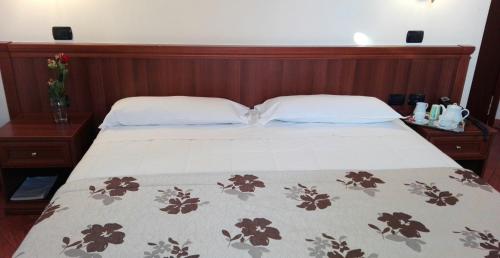 a bed with a wooden head board and two pillows at Corte Degli Estensi in Formigine