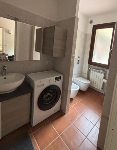 a bathroom with a washing machine and a sink at Condominio Villa Helios in Cuasso Al Monte