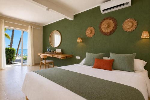 a bedroom with a large bed with a green wall at Lankraz Hotel Mauritius in Port Louis