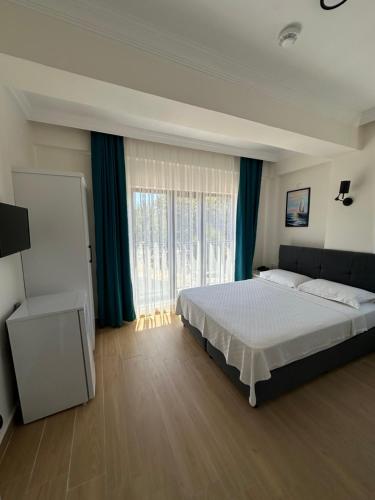 a bedroom with a bed and a large window at Sevgi Hotel in Ezine