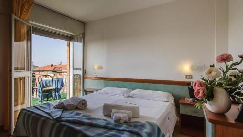 a bedroom with a bed with towels on it at Hotel Kennedy in Lido di Savio