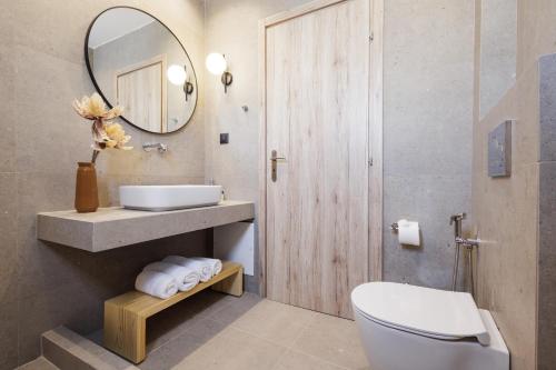 a bathroom with a sink and a toilet and a mirror at Inoe Boutique Hotel in Kamari