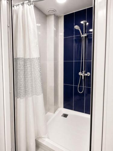 a bathroom with a shower with a white shower curtain at White Hotel in Yerevan