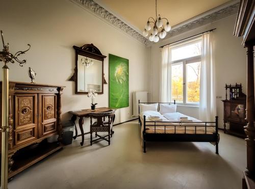 a bedroom with a bed and a table and a window at Villa Dietel Greiz in Greiz