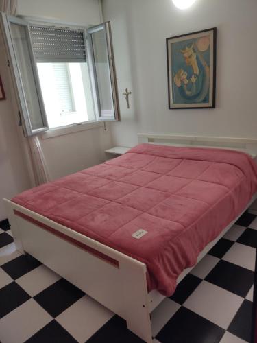 a bedroom with a large bed with a red bedspread at FronteMare in Lido di Pomposa
