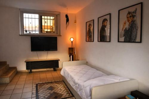 a living room with a couch and a flat screen tv at The Other Side in Lainate