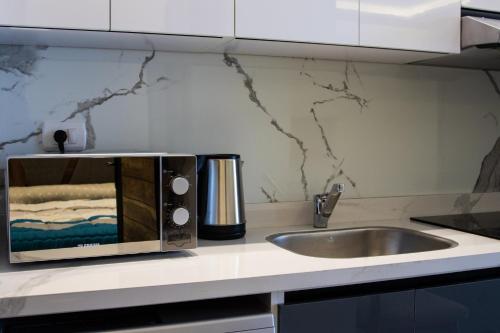 a microwave on a kitchen counter with a sink at Bohemia palace in Hurghada